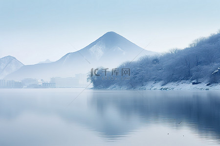 韩国雪背景图片_被雪和山包围的湖，一侧有水