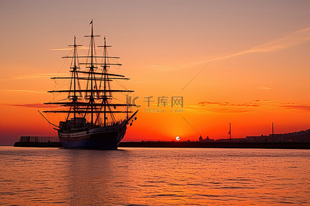 旅游酒店背景图片_日落时一艘高船在水面上