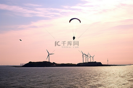 滑翔伞手绘背景图片_滑翔伞在风力涡轮机的海洋上空飞行