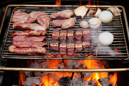 切洋葱流泪背景图片_一个烤架，里面装满了各种肉类洋葱和在烤架上煮熟的肉