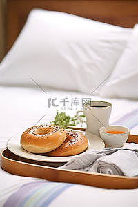 早餐室，白色床上的托盘上放着两个百吉饼三明治，枕头靠近相机