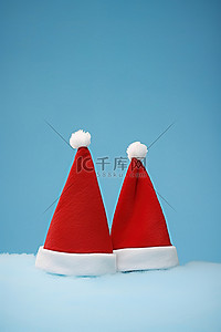 蓝色背景上的两顶圣诞老人帽子