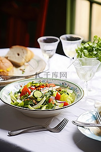 沙拉背景图片_桌上的沙拉，上面有蔬菜和盘子