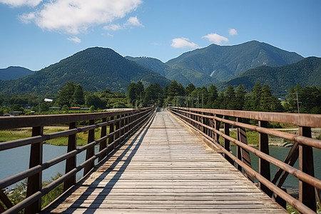 水里背景图片_一座木桥通向空旷山谷中的山脉