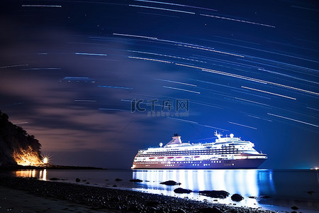 太阳海滩背景图片_夜色中的游轮围绕海滩星轨