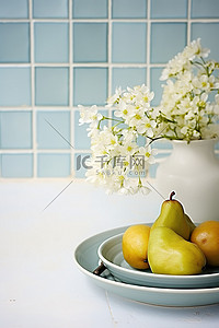 蓝白瓷砖墙上放着一个白盘和一碗梨，上面有花
