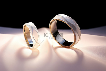 结婚戒指背景图片_两个带白丝带的结婚戒指
