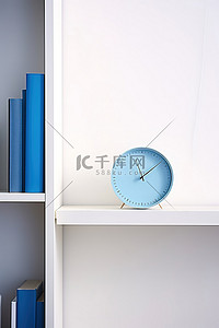在白色的墙上，书旁边有蓝色的时钟
