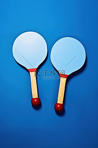 乒乓球球背景图片_蓝色背景上的两个乒乓球拍，中间有一个球