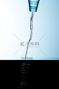 纯净装水背景图片_一个装水的瓶子，下面有一个玻璃杯