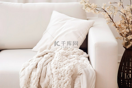 沙发和枕头旁边有一张简单的白色休闲毯