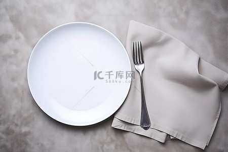 餐巾旁边有带叉子和刀子的白盘