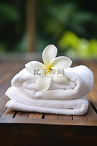 拿着毛巾背景图片_木甲板上的白毛巾拿着一朵花