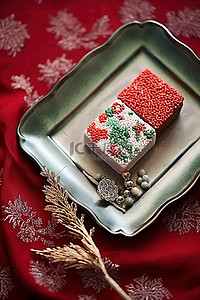 白盘子psd背景图片_一块巧克力放在盘子上，上面有装饰品和丝带