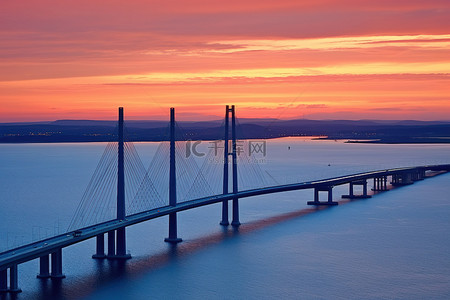 夕阳落下背景图片_夕阳下的一座桥在水面上落下