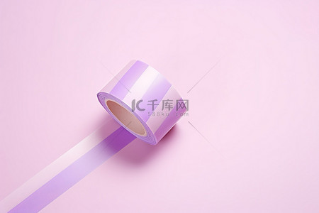紫色纸胶带卷在粉红色和白色背景上的紫色条纹上