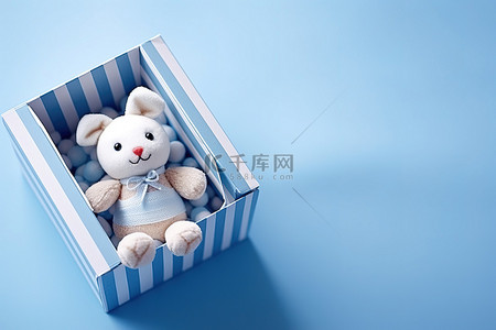 一只玩具兔子坐在蓝色背景的盒子里