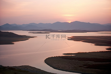 天空的陆地背景图片_湖边的日出，周围是陆地