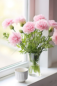 窗台上有粉色康乃馨，旁边是一个旧杯子