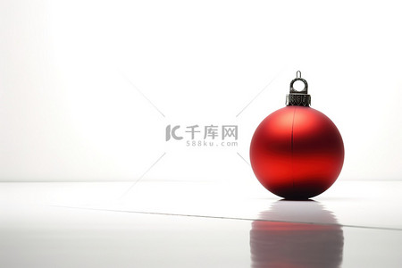 白的圣诞球背景图片_红色和黑色的圣诞球位于白色表面上
