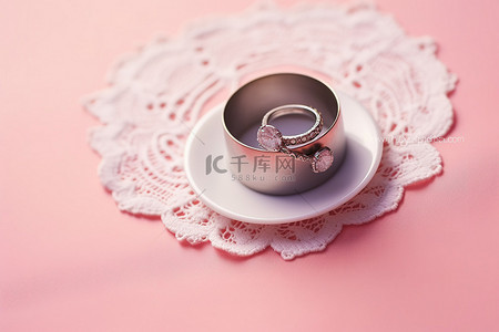 结婚戒指放在粉色桌子上的桌布上