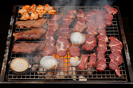一个烤架，里面装满了各种肉类洋葱和在烤架上煮熟的肉