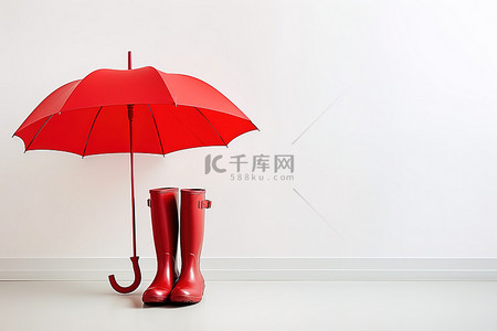 站立在白墙上的红色靴子和雨伞