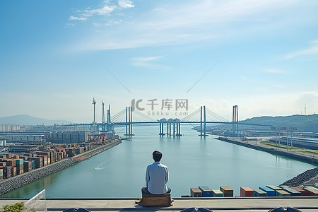 一个人坐在桥上俯瞰桥梁和港口