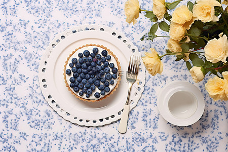 一捆东西背景图片_桌上放着蓝莓馅饼，上面放着鲜花和其他东西