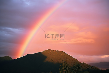当夏威夷的日落时，可以看到粉红色和紫色的彩虹