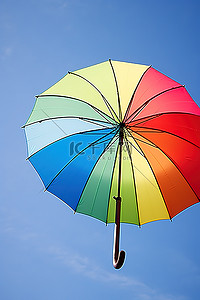 撑着背景图片_天空中撑着一把彩虹伞，映衬着蓝天
