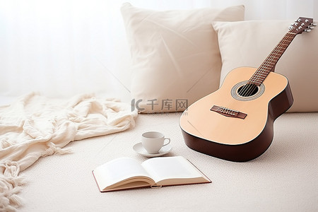 一把艾草背景图片_白色羊毛地毯上的一把吉他，上面有一本空书和一个杯子
