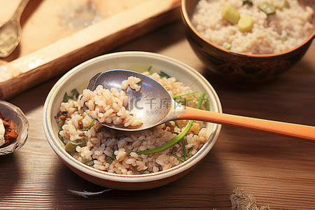 桌上放着两勺米饭，上面放着一碗米饭蔬菜和一个盘子