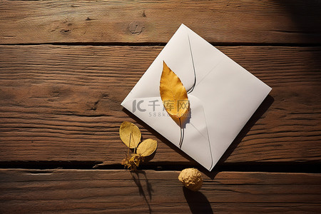 白色信封和叶子，木桌上有叶子和黄色铅笔