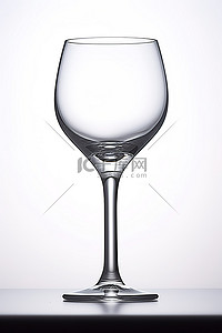 白色背景的桌子上放着一个透明的酒杯