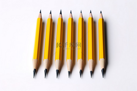 白色表面上的五支黄色铅笔