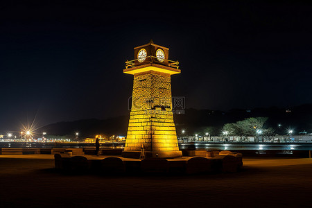 童话钟楼背景图片_夜晚海边矗立的钟楼