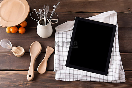 炊具刀抹布抹布和木桌上的黑色 ipad 平板电脑屏幕