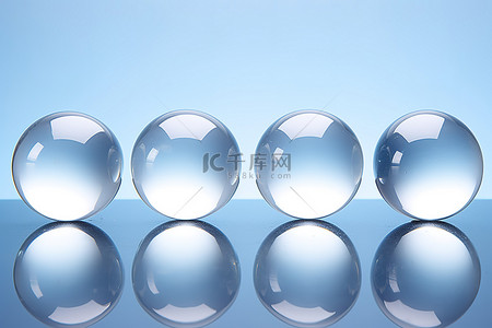 透明玻璃球背景图片_蓝色背景上的四个高品质透明玻璃球