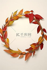 绿色的大叶子背景图片_一个绿色的花环，上面有多个秋天的彩色叶子和树枝