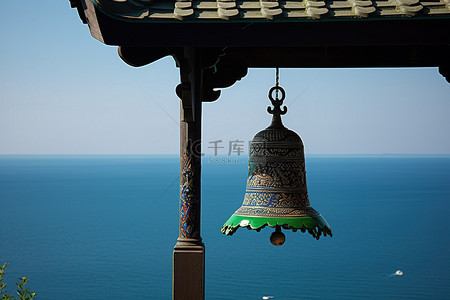 钟声敲响背景图片_海上塔上悬挂着寺庙的钟声