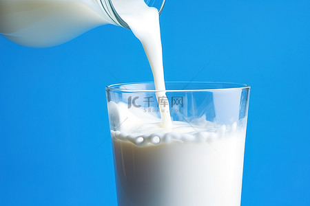 乳制品背景背景图片_蓝色背景中牛奶被倒入一杯水中
