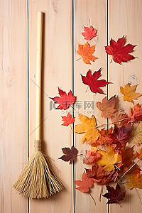 在背景图片_秋天的树叶和扫帚在桌子上