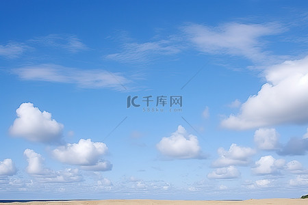 沙漠背景背景图片_蓝天白云和沙漠海滩上的悬崖