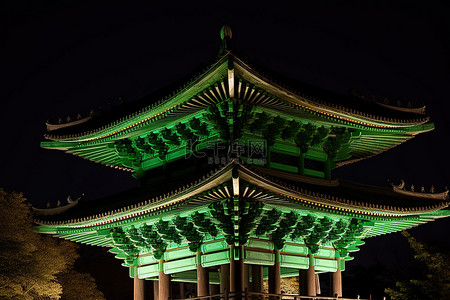 一座宝塔在夜间亮起非常明亮的绿色灯光