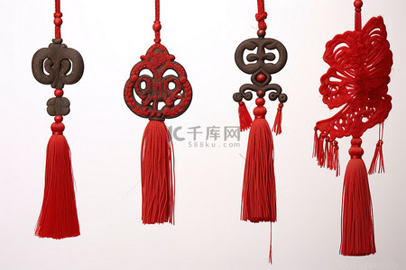 中国装饰品背景图片_四个红色流苏挂件，上面有一条龙中国功夫和帽子装饰品