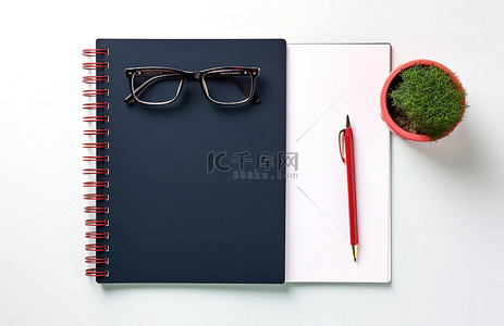 笔记本顶视图背景图片_带眼镜铅笔和笔记本的黑色笔记本的顶视图