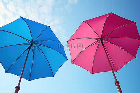 两把五颜六色的雨伞在蓝天上升起