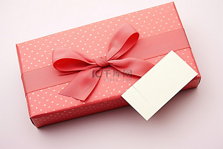 信封旁边的粉红色礼品盒