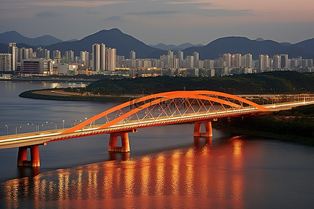 韩国的橙色铁路桥横跨水面城市和山脉